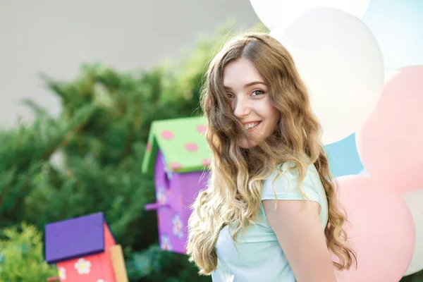 Schöne Frau mit fliegenden bunten Ballons — Stockfoto