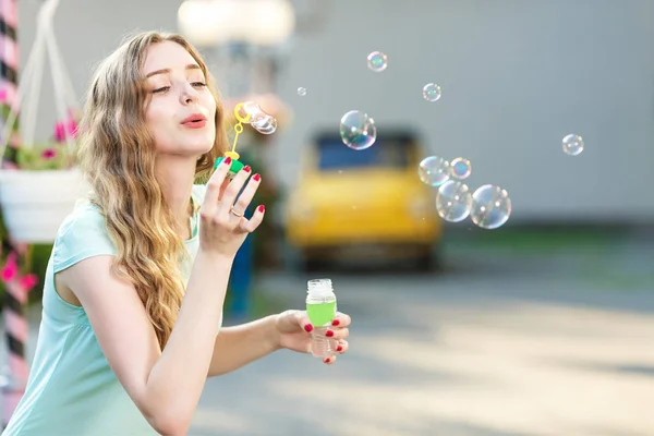 Mulher feliz soprando bolhas de sabão — Fotografia de Stock