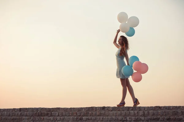 Bela mulher com voando balões multicoloridos — Fotografia de Stock