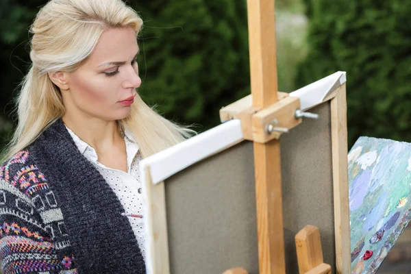 Seniman wanita dengan kuas di tangannya menggambar di atas kanvas — Stok Foto