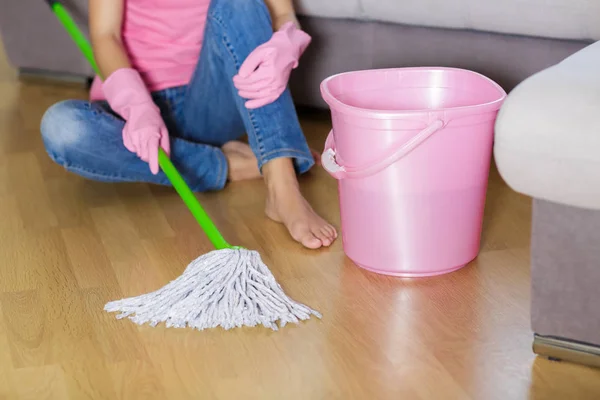 Tired woman in protective gloves is sitting near bucket. — Stock Photo, Image