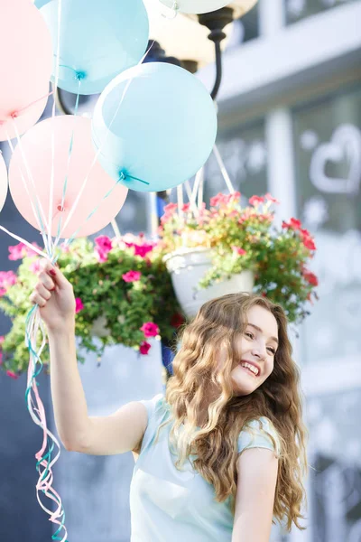 Hermosa mujer con vuelo multicolor globos — Foto de Stock