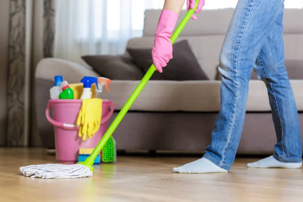 Vrouw in beschermende handschoenen met behulp van een NAT-mop tijdens het schoonmaken van de vloer — Stockfoto