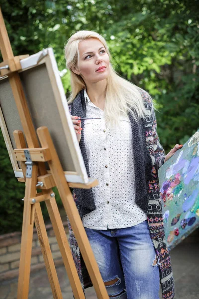 Seniman wanita dengan kuas di tangannya menggambar di atas kanvas — Stok Foto