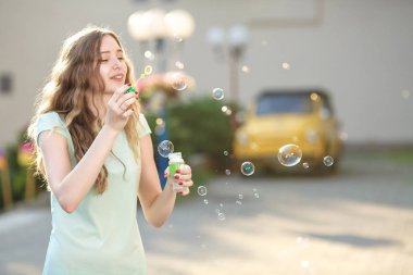 mutlu bir kadın sabun köpüğü üfleme