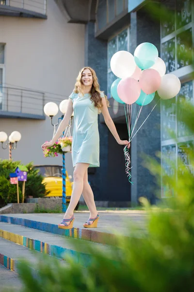 Hermosa mujer con vuelo multicolor globos — Foto de Stock