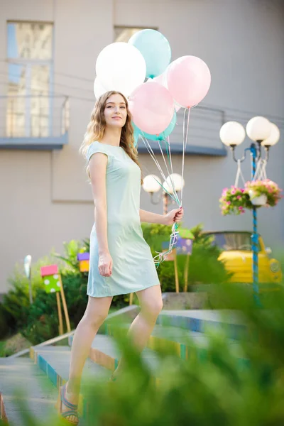 Hermosa mujer con vuelo multicolor globos — Foto de Stock
