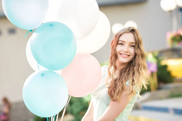 Hermosa mujer con vuelo multicolor globos — Foto de Stock