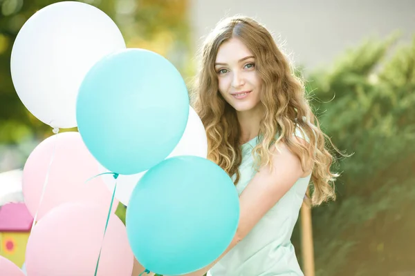 Hermosa mujer con vuelo multicolor globos — Foto de Stock