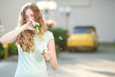 mutlu bir kadın sabun köpüğü üfleme