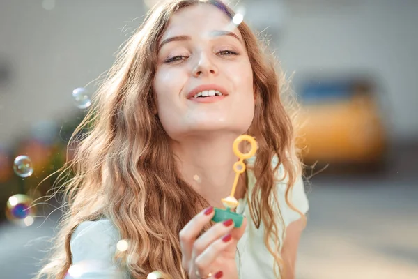 Счастливая женщина, пускающая мыльные пузыри — стоковое фото
