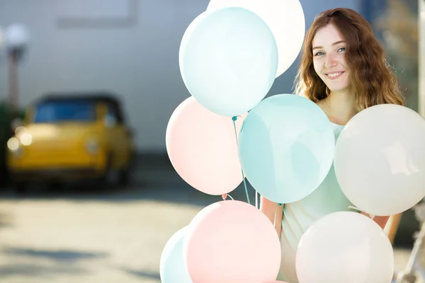 Vacker kvinna med flygande mångfärgade ballonger — Stockfoto