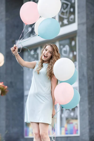 Bela mulher com voando balões multicoloridos — Fotografia de Stock