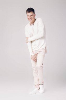 yakışıklı genç adam beyaz bir kazak ve pantolon