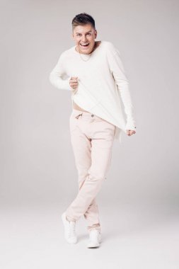 yakışıklı genç adam beyaz bir kazak ve pantolon