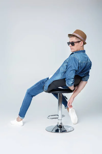 Hombre guapo en denim se sienta en la silla — Foto de Stock