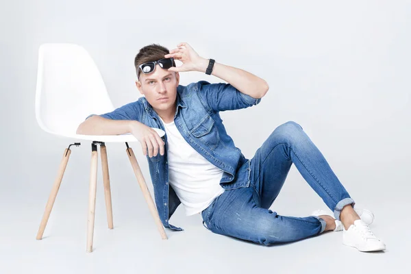 Hombre guapo en denim se sienta en la silla — Foto de Stock