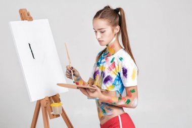 renkli boya lekeli kadın ressam tuval üzerine çizer.