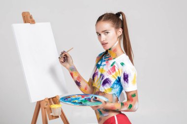 renkli boya lekeli kadın ressam tuval üzerine çizer.