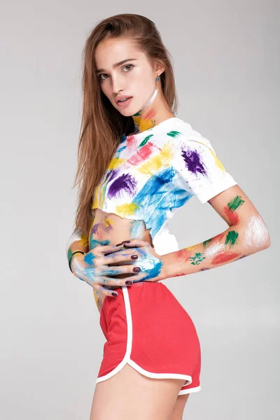 Mujer joven untada en pintura multicolor . — Foto de Stock