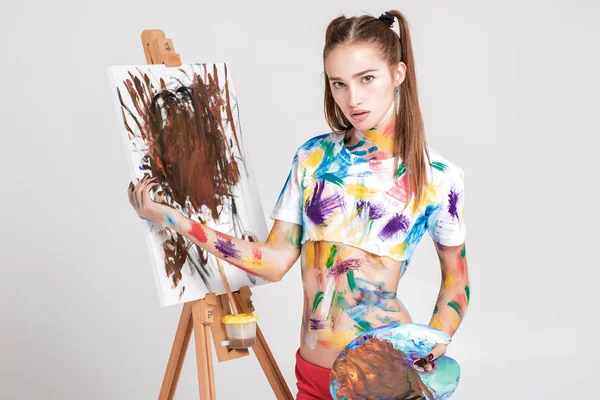 renkli boya lekeli kadın ressam tuval üzerine çizer.