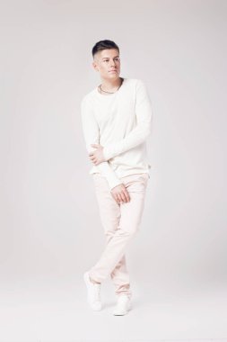 yakışıklı genç adam beyaz bir kazak ve pantolon