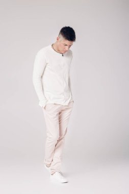 yakışıklı genç adam beyaz bir kazak ve pantolon