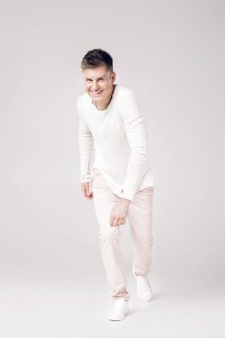 yakışıklı genç adam beyaz bir kazak ve pantolon