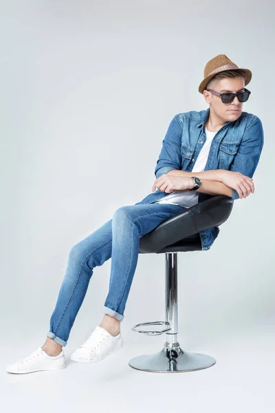 Hombre guapo en denim se sienta en la silla — Foto de Stock