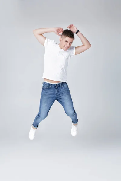 Bel homme en jeans et veste sautant — Photo