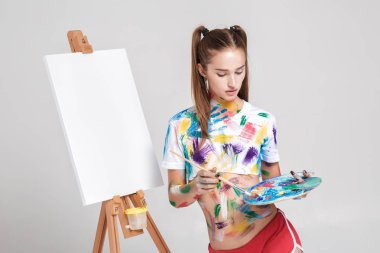 renkli boya lekeli kadın ressam tuval üzerine çizer.