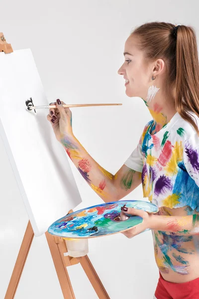 renkli boya lekeli kadın ressam tuval üzerine çizer.