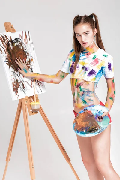 renkli boya lekeli kadın ressam tuval üzerine çizer.