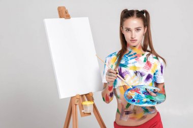 renkli boya lekeli kadın ressam tuval üzerine çizer.