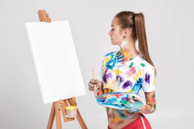 renkli boya lekeli kadın ressam tuval üzerine çizer.