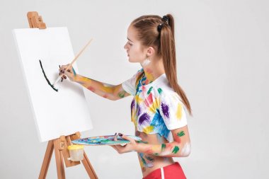 renkli boya lekeli kadın ressam tuval üzerine çizer.