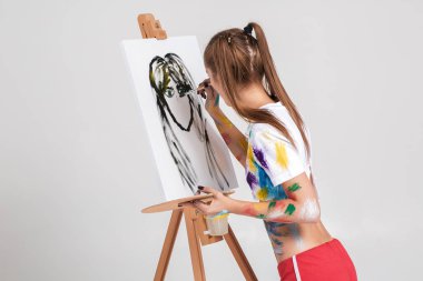 renkli boya lekeli kadın ressam tuval üzerine çizer.