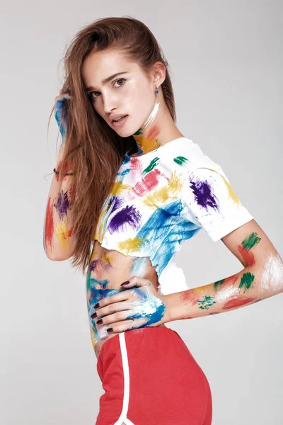 Mujer joven untada en pintura multicolor . — Foto de Stock