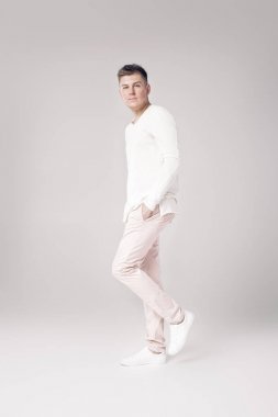yakışıklı genç adam beyaz bir kazak ve pantolon