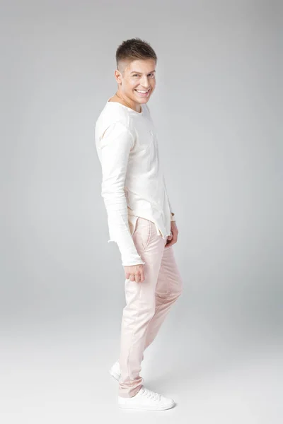 Красивий молодий чоловік в білому светрі і штанях — стокове фото