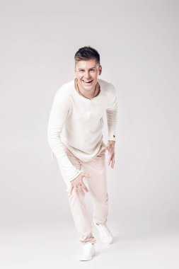 yakışıklı genç adam beyaz bir kazak ve pantolon