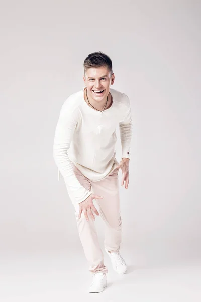 Beau jeune homme en pull blanc et pantalon — Photo