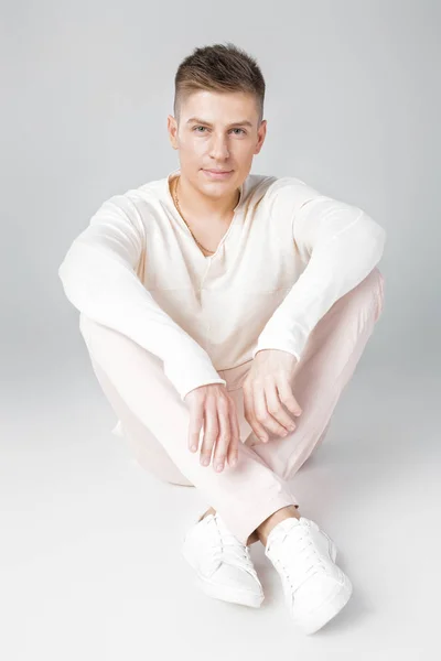 Bello giovane uomo in un maglione bianco — Foto Stock