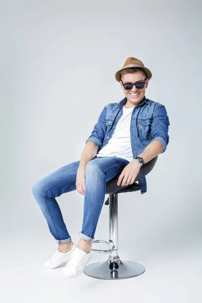 Handsome man in denim sits on chair — Stock Photo, Image