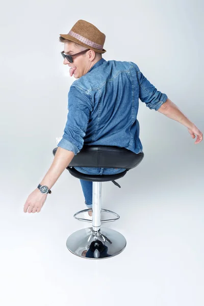 Stilig man i denim sitter på stol — Stockfoto