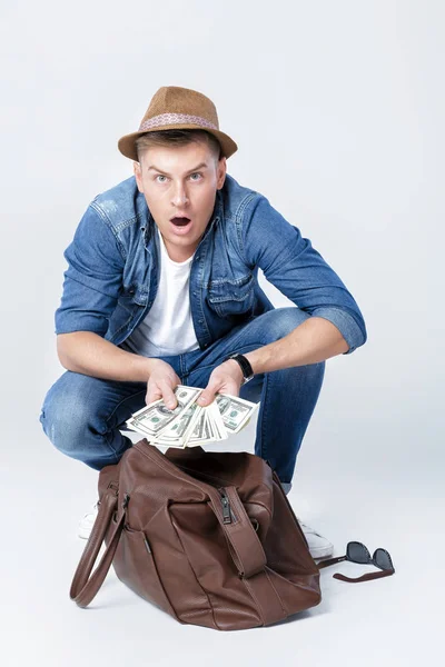 Mężczyzna w kapeluszu znalezione pieniądze w skórzanym woreczku — Zdjęcie stockowe
