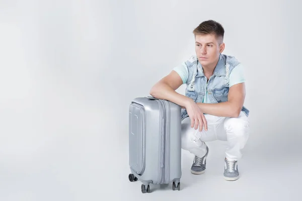 Hombre joven en camisa azul con maleta — Foto de Stock