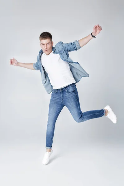 Bel homme en jeans et veste sautant — Photo