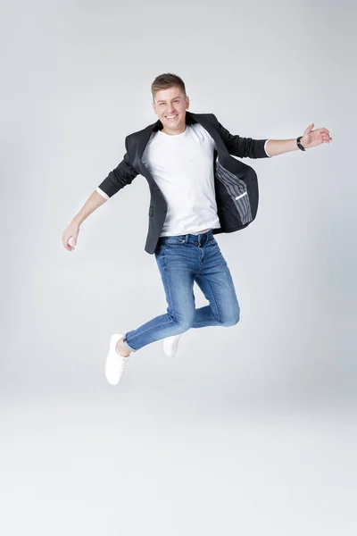 Hombre guapo en jeans y chaqueta saltando — Foto de Stock