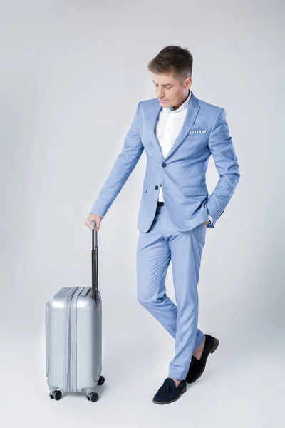 Hombre joven en traje azul con maleta — Foto de Stock